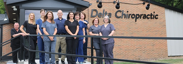 Chiropractor Lansing MI Charles Roost And Daniel Dail With Team Members Outside Office